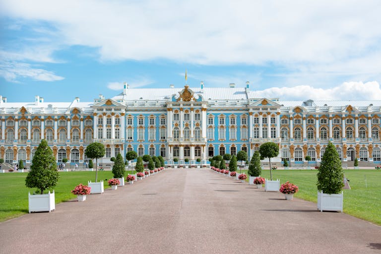 Beautiful summer view of the iconic Catherine Palace with vibrant gardens and clear blue sky.