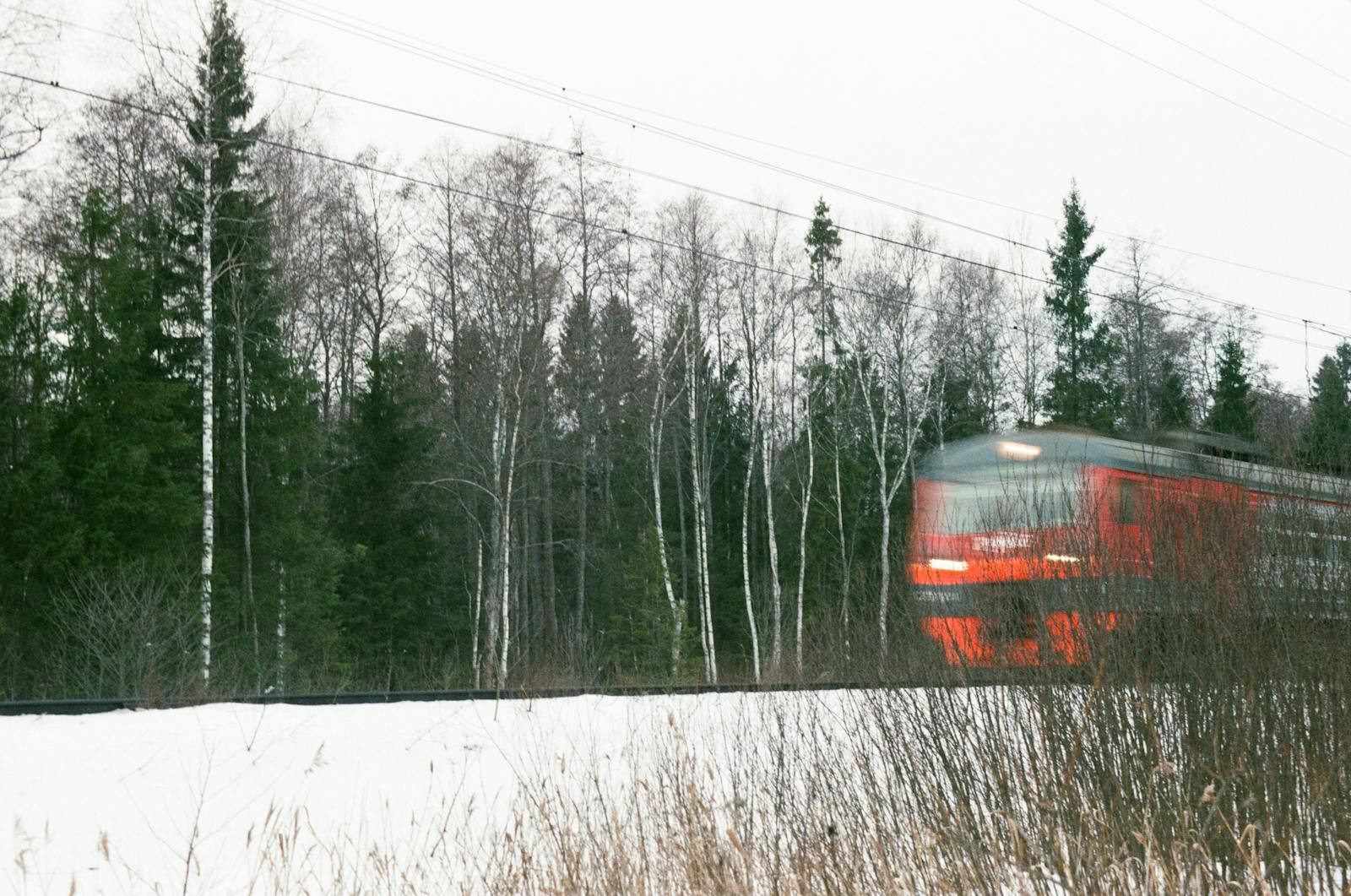 Red Russian train crossing a snowy forest in winter, Moscow-Kazan route