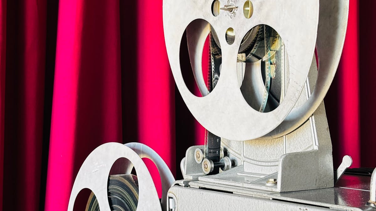 Vintage film projector in front of a red curtain, a symbol of classic Russian cinema