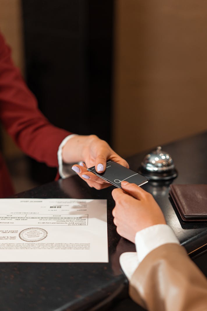 Hotel receptionist handing a key card to a guest during check-in