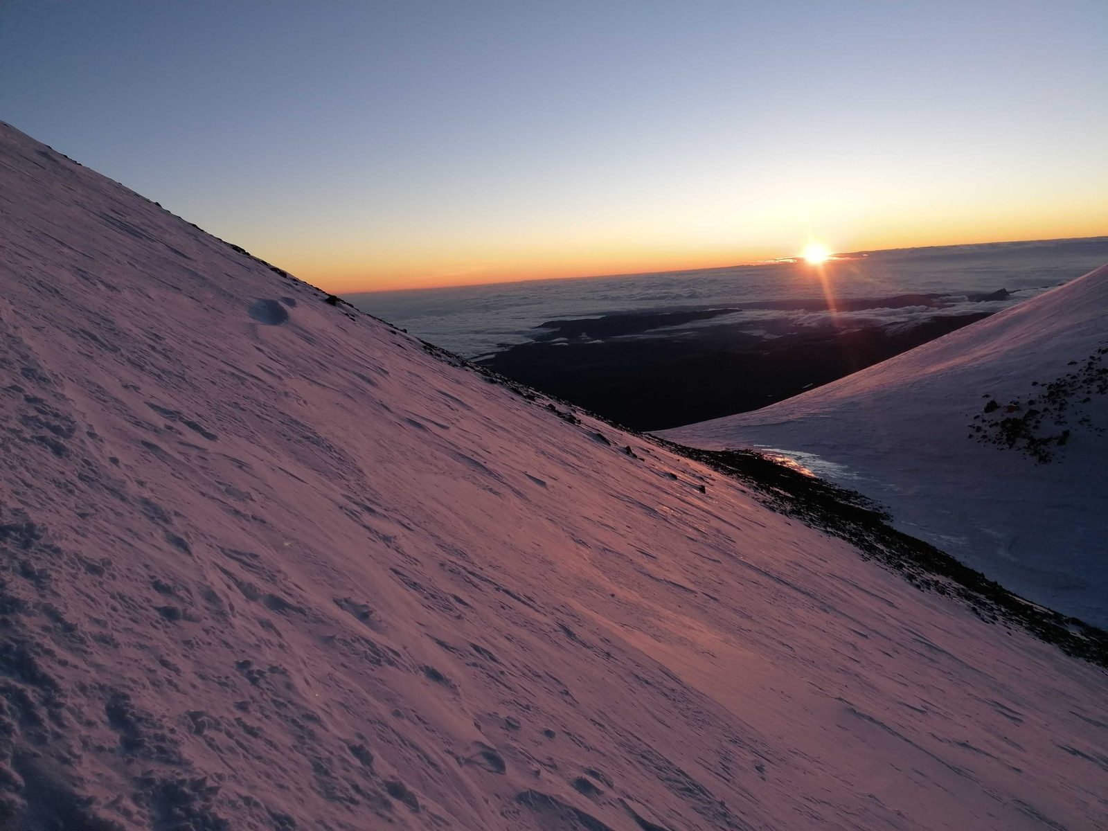 Sunrise between the two summits of Mount Elbrus, above a sea of clouds