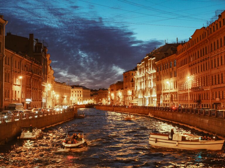 Twilight view of a St. Petersburg canal with illuminated buildings and boats