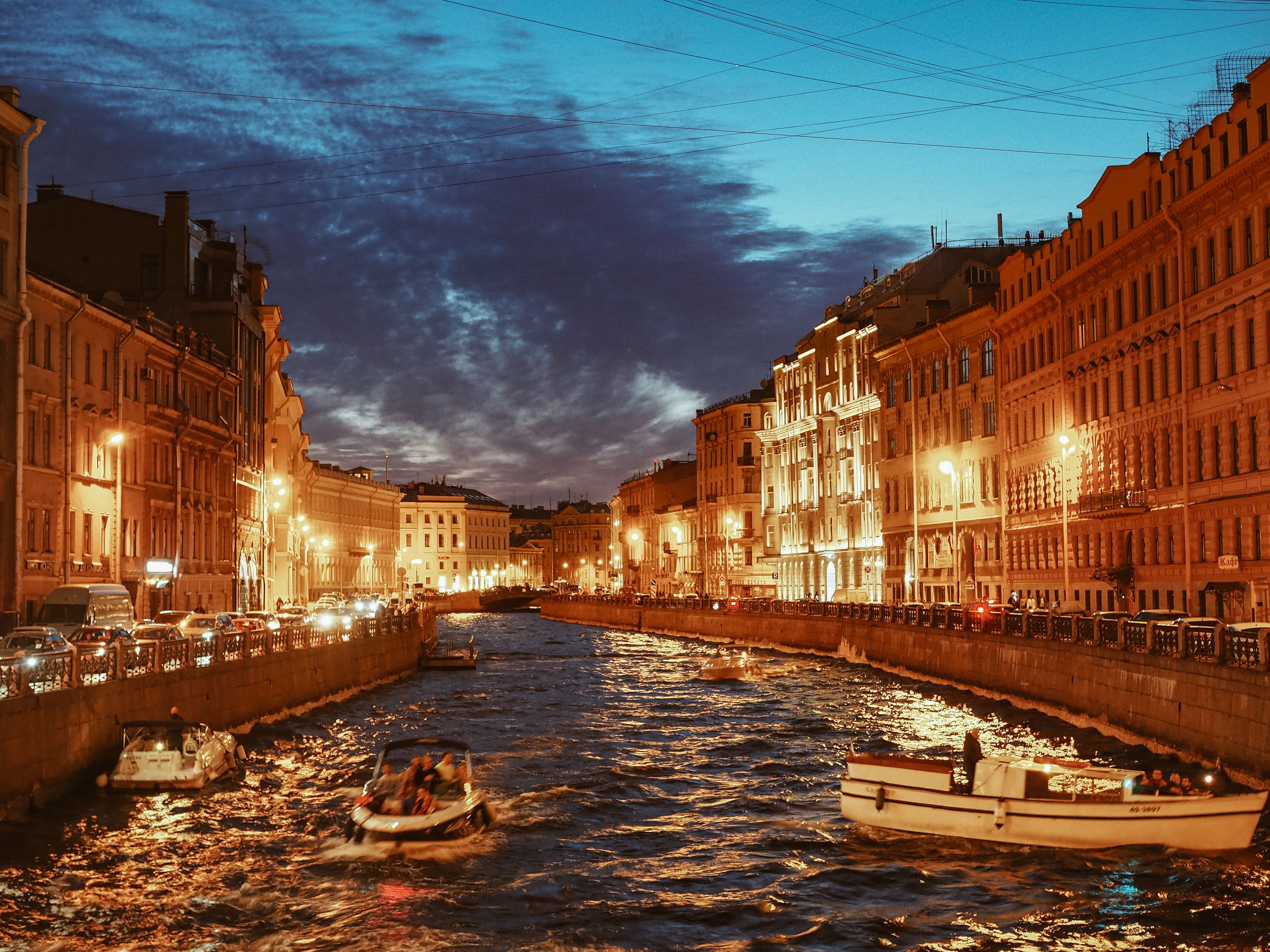 Twilight view of a St. Petersburg canal with illuminated buildings and boats