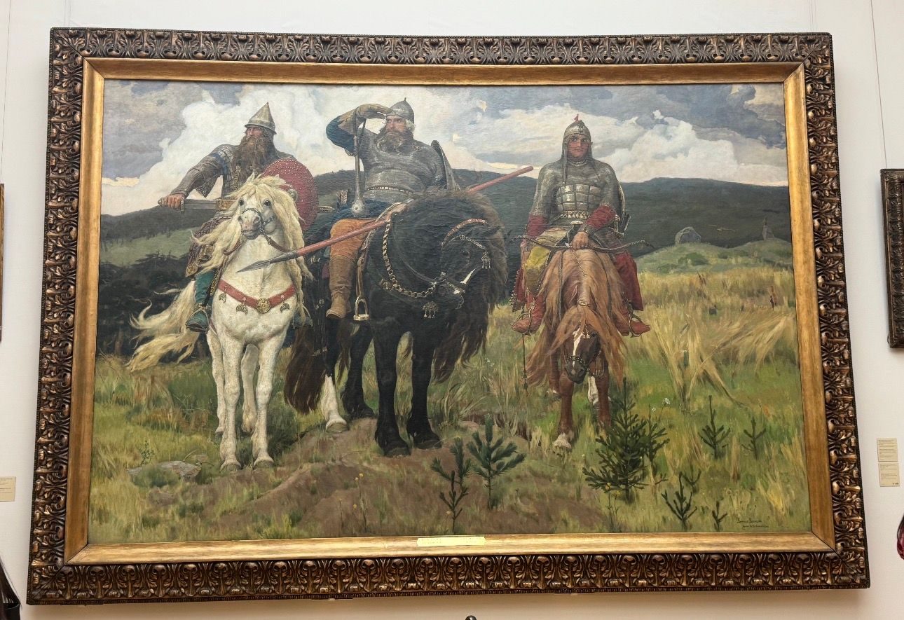 Large framed painting of three mounted Russian warriors on a gallery wall