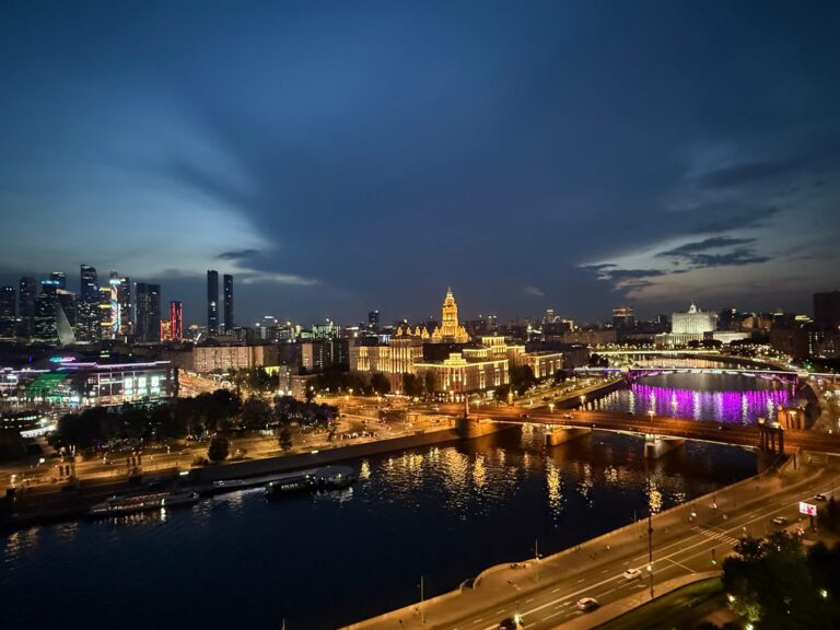 Moscow skyline at night with the Moscow City towers and an illuminated Stalin-era skyscraper by the river