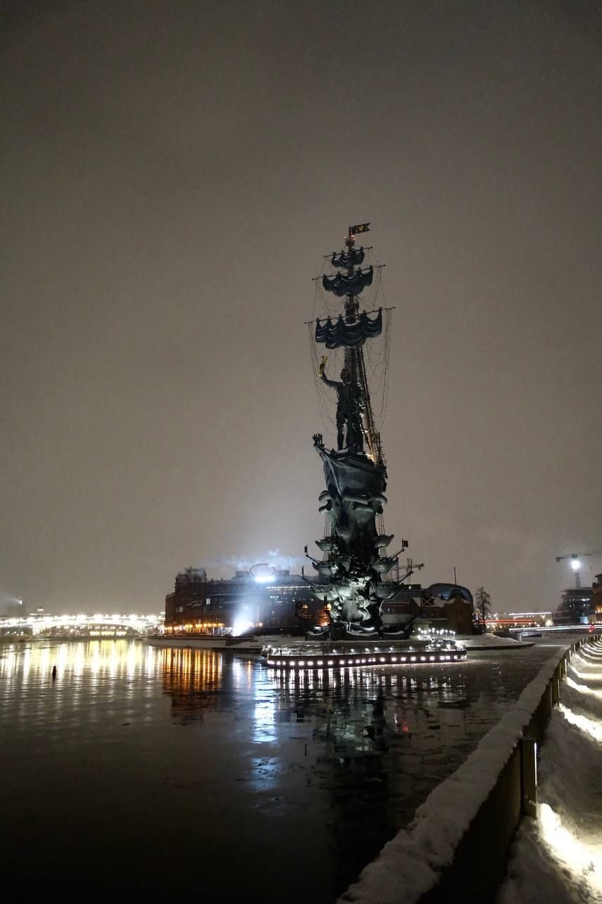 The monument to Peter the Great lit up at night beside the Moskva River