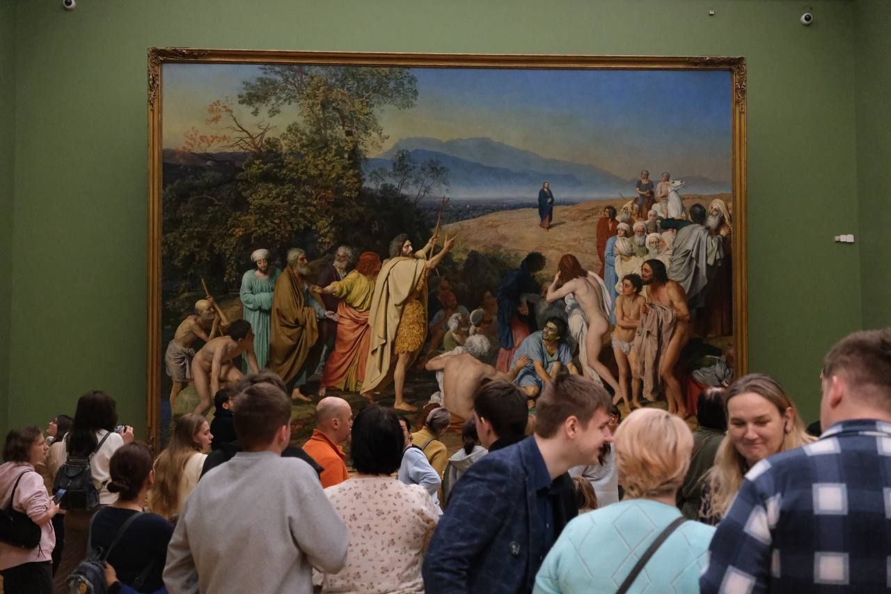 Visitors gathered in front of a large painting in a hall of the Tretyakov Gallery in Moscow