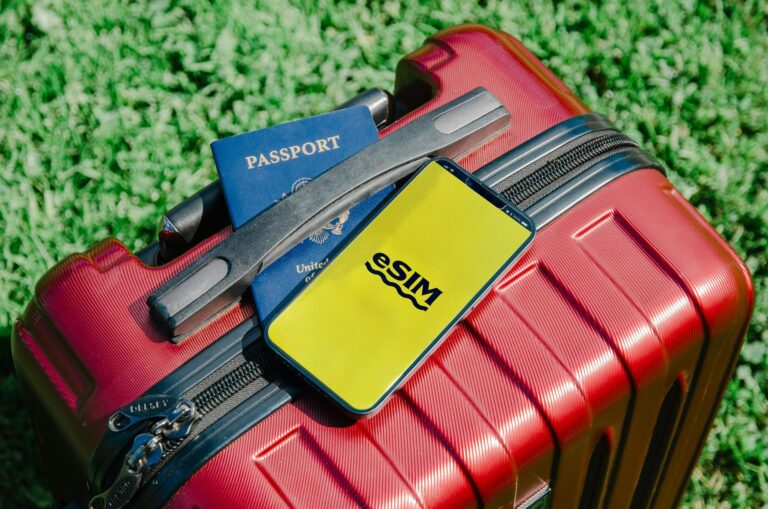 Smartphone with an eSIM, a passport and a red suitcase, ready for a trip to Russia